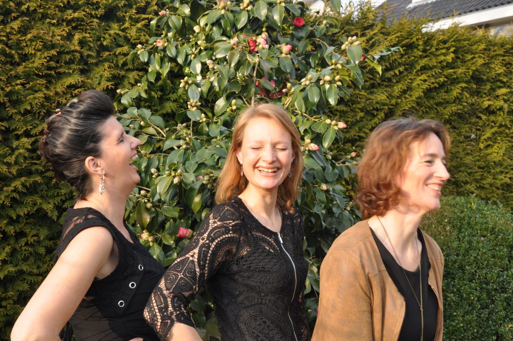 Drie zangeressen van The VocalS lachend buiten